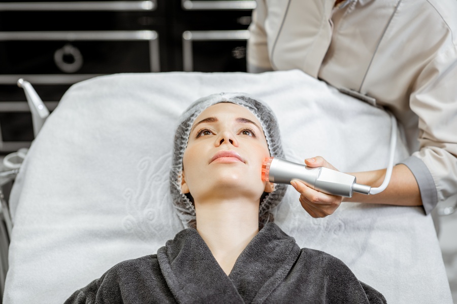 Practitioner applying a HIFU handpiece along a Glasgow client’s lower face