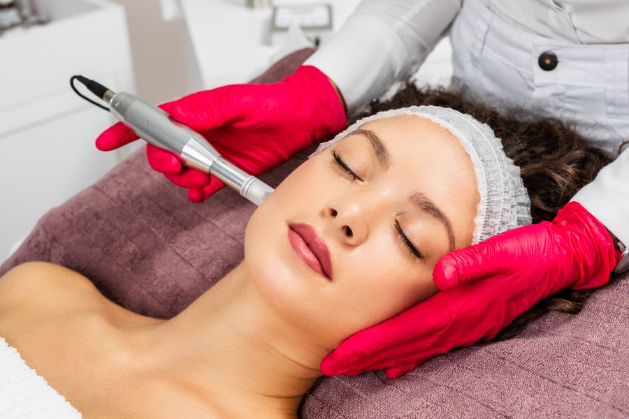Practitioner holding a clinical microneedling pen above cleansed skin